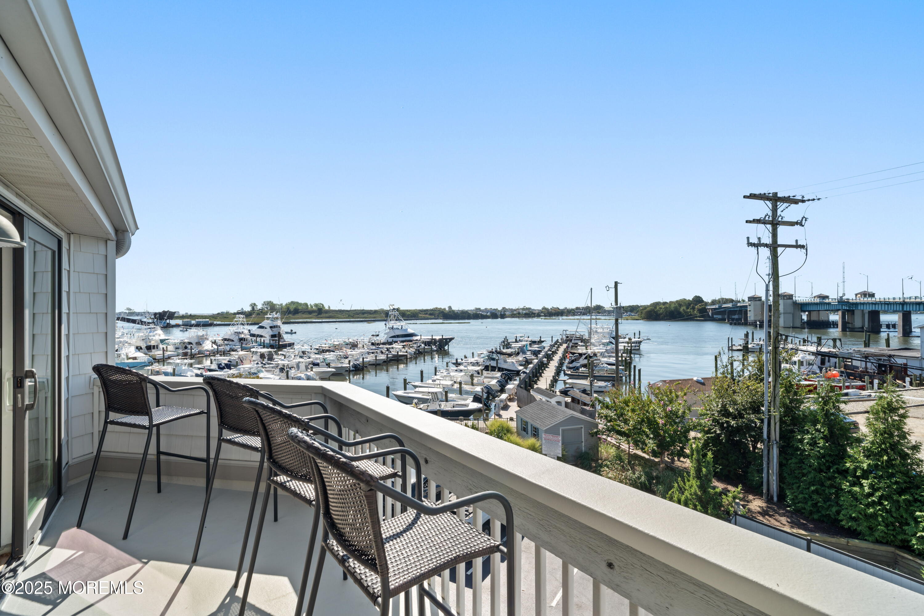 118 Ashley Avenue Brielle, NJ 08730 - Photo 25 of 34 a view of a balcony with wooden chairs and floor to ceiling window