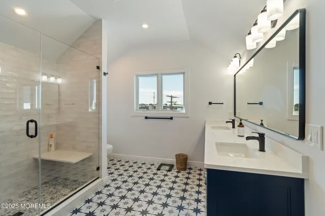 a bathroom with a sink a toilet and shower