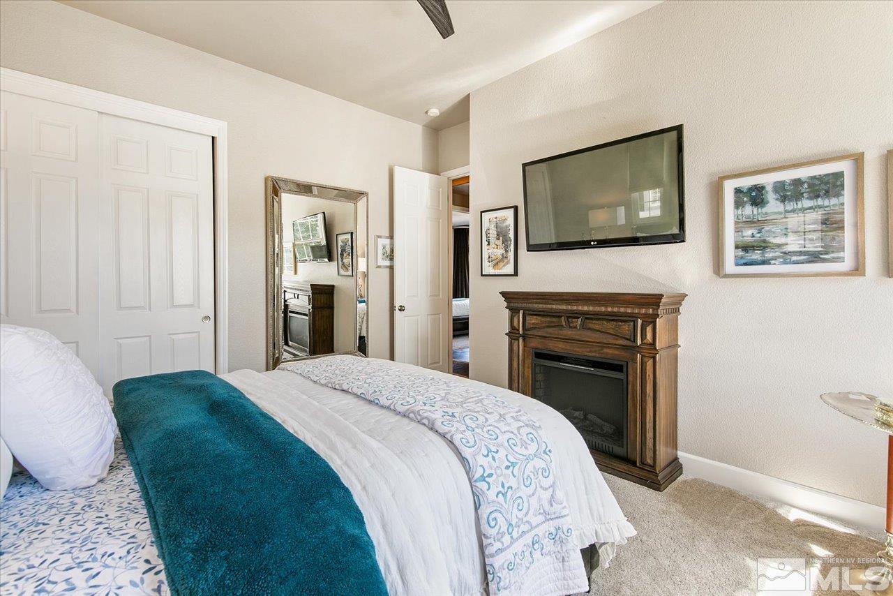 2956 Flint Ridge Court Reno, NV 89511 - Photo 27 of 40 a spacious bedroom with a bed and a flat screen tv