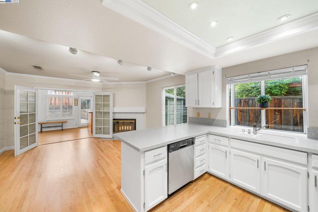a kitchen with a sink windows and white cabinets
