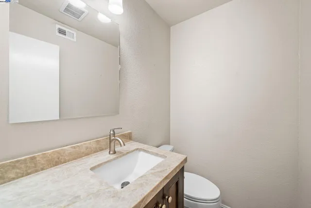 a bathroom with a sink a toilet and mirror