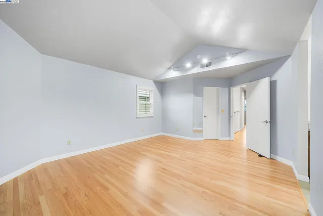 a view of an empty room with chandelier and a window