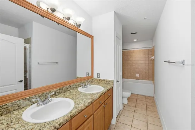 an empty room with wooden floor and a chandelier