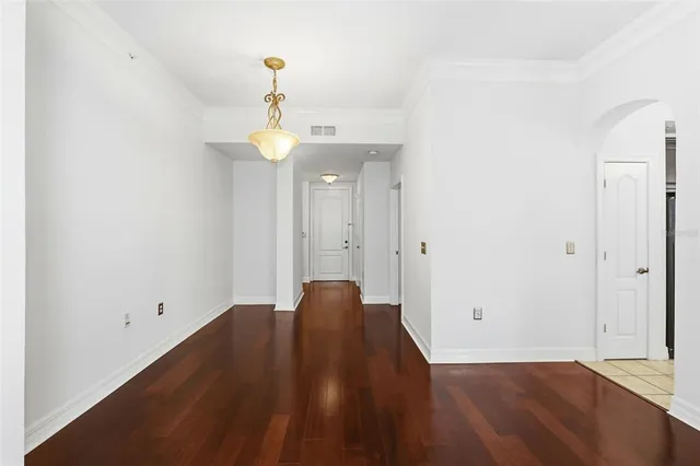 a view of a livingroom with wooden floor and kitchen space