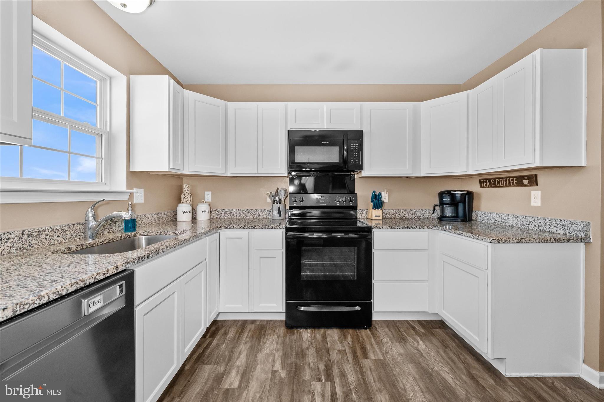 312 Doylestown Road Smyrna, DE 19977 - Photo 15 of 36 a kitchen with granite countertop a sink dishwasher a stove and a microwave oven with cabinets
