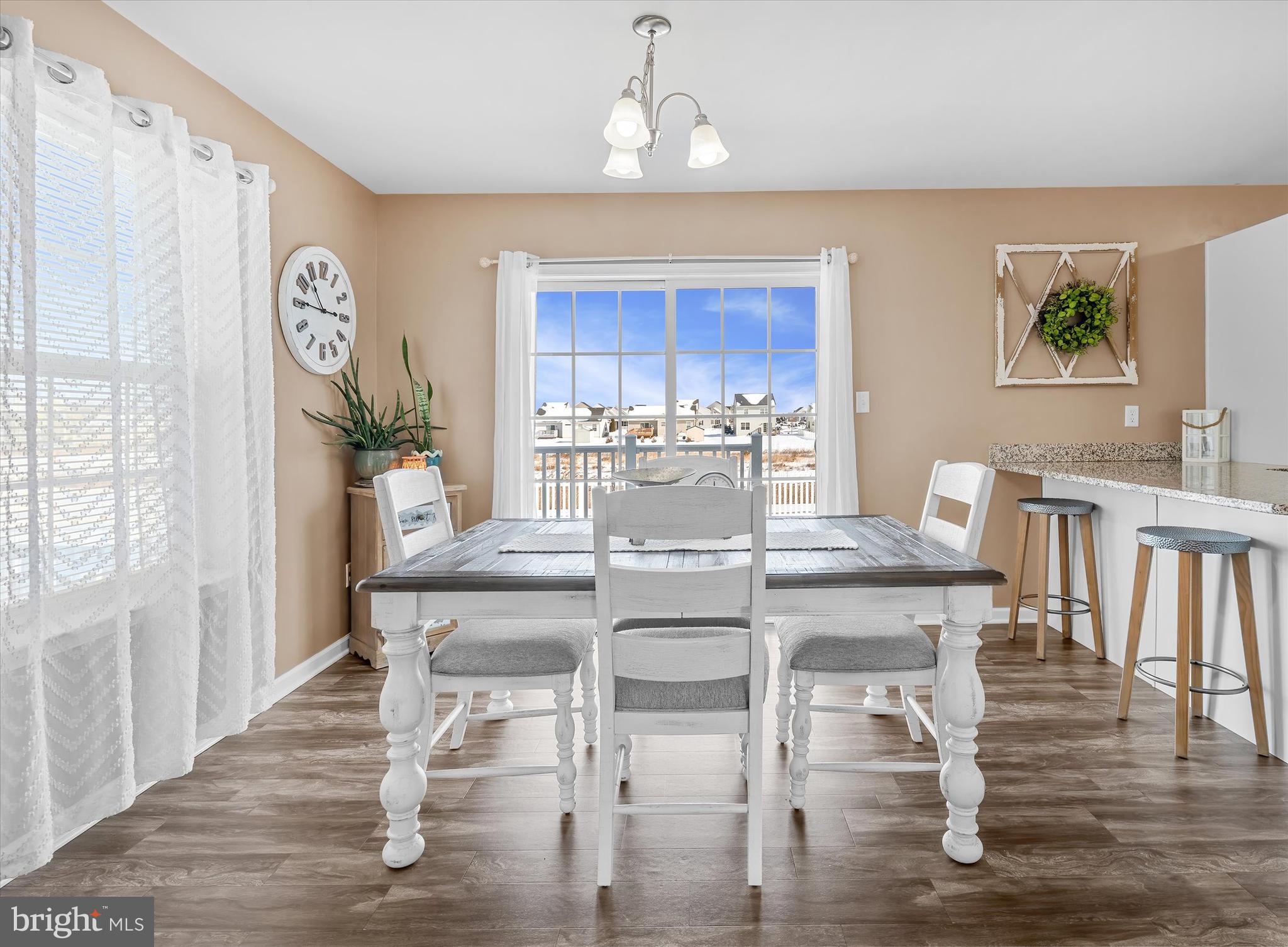 312 Doylestown Road Smyrna, DE 19977 - Photo 10 of 36 a dining room with wooden floor a chandelier a wooden table and chairs