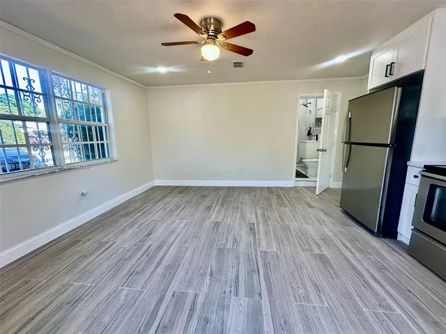 a view of a livingroom with wooden floor and a ceiling fan