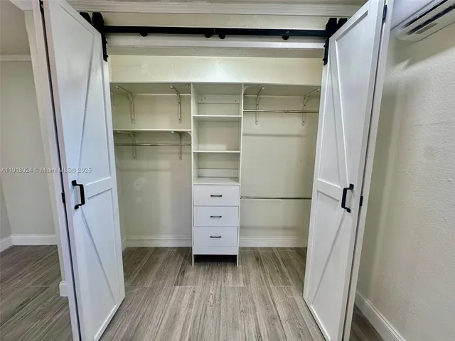 a view of walk in closet with wooden floor