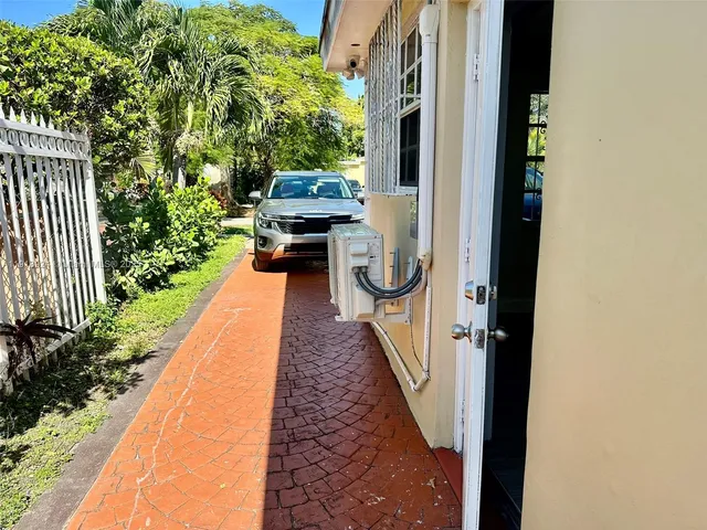 a view of a pathway of a house with backyard and sitting area