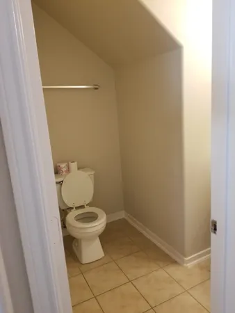 a view of staircase with white walls and chandelier