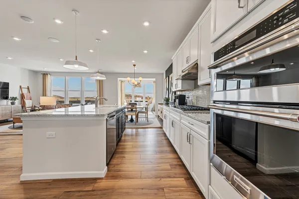 a kitchen with counter top space stainless steel appliances and wooden floor