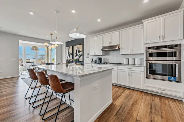 a kitchen with stainless steel appliances kitchen island granite countertop a stove a sink and a microwave