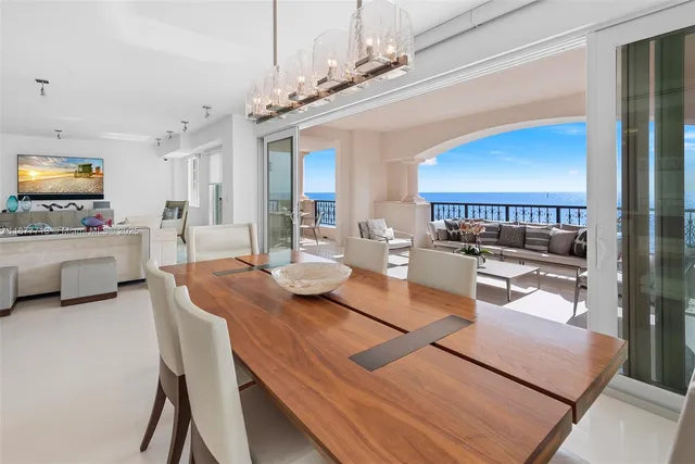 a living room with furniture a table and kitchen view