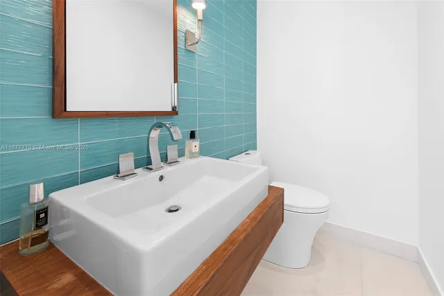 a kitchen with stainless steel appliances kitchen island granite countertop a refrigerator a stove and a sink with wooden floor