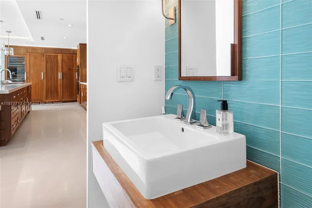 a dining hall with stainless steel appliances a dining table and chairs with the floor to ceiling window