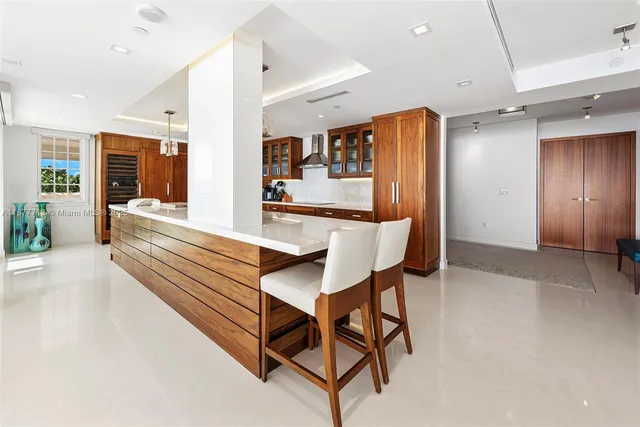 a large kitchen with stainless steel appliances a sink and a refrigerator