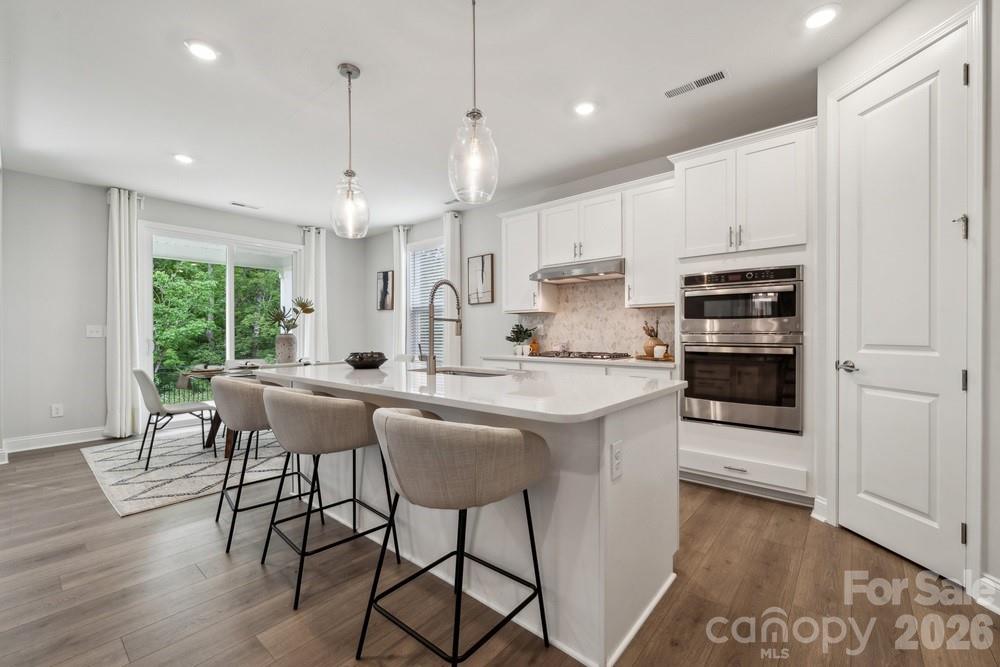 a kitchen with kitchen island a dining table and chairs