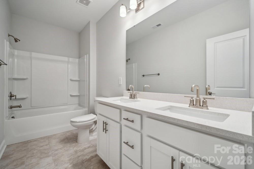 5041 Duval Circle Tega Cay, SC 29708 - Photo 31 of 47 a bathroom with a double vanity sink toilet mirror and bathtub
