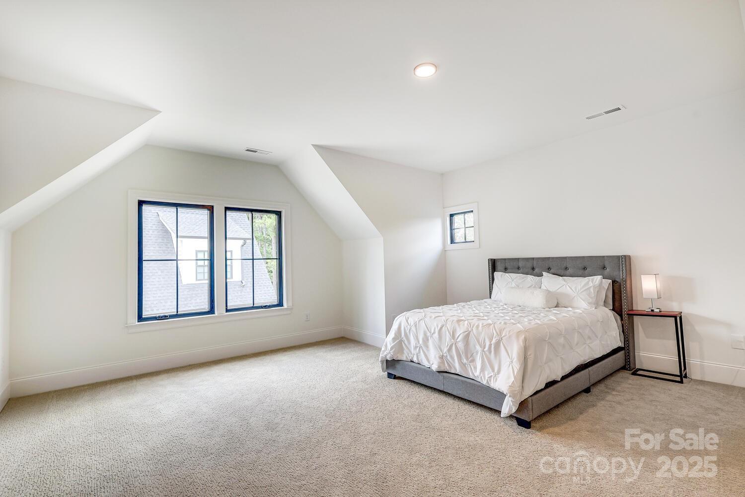 5511 Fairview Road Charlotte, NC 28209 - Photo 31 of 45 a spacious bedroom with a bed lamp and a window