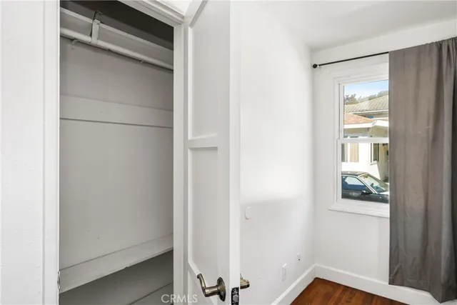 a view of empty room with wooden floor and ceiling fan