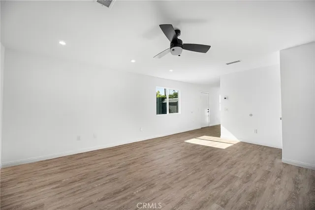 a view of a room with wooden floor and a window