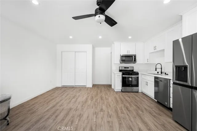 a kitchen with white cabinets stainless steel appliances and sink