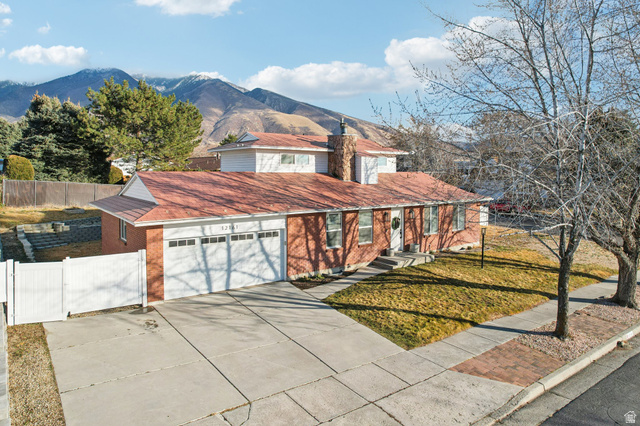 12161 Spring Ridge Circle Sandy, UT 84094 - Photo 1 of 1 Traditional-style house with driveway, a mountain view, brick siding, a gate, and an attached garage