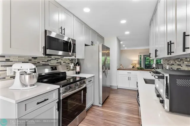 a kitchen with stainless steel appliances a stove sink microwave and cabinets