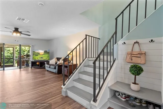 a view of a hallway with wooden floor and stairs