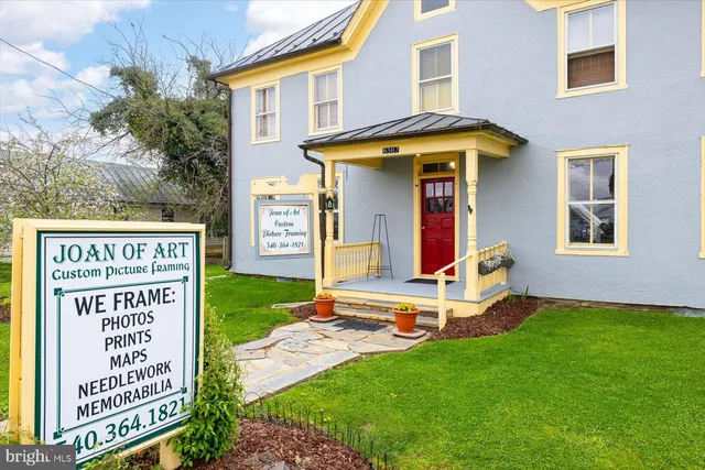 a sign that is sitting in front of a brick house