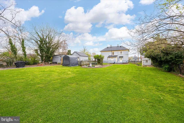 a view of a house with a big yard and large trees