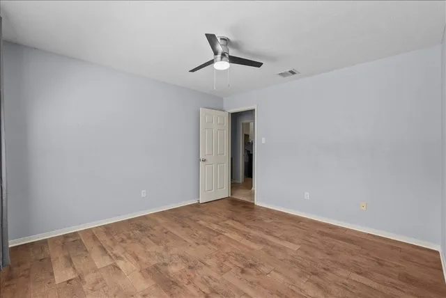 a view of a room with wooden floor and a window