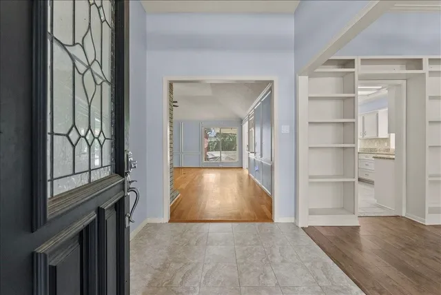 a view of gallery with wooden floor and a window
