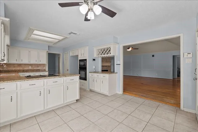 a large white kitchen with cabinets