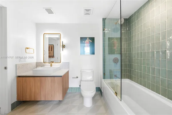 a bathroom with a granite countertop sink a toilet and shower