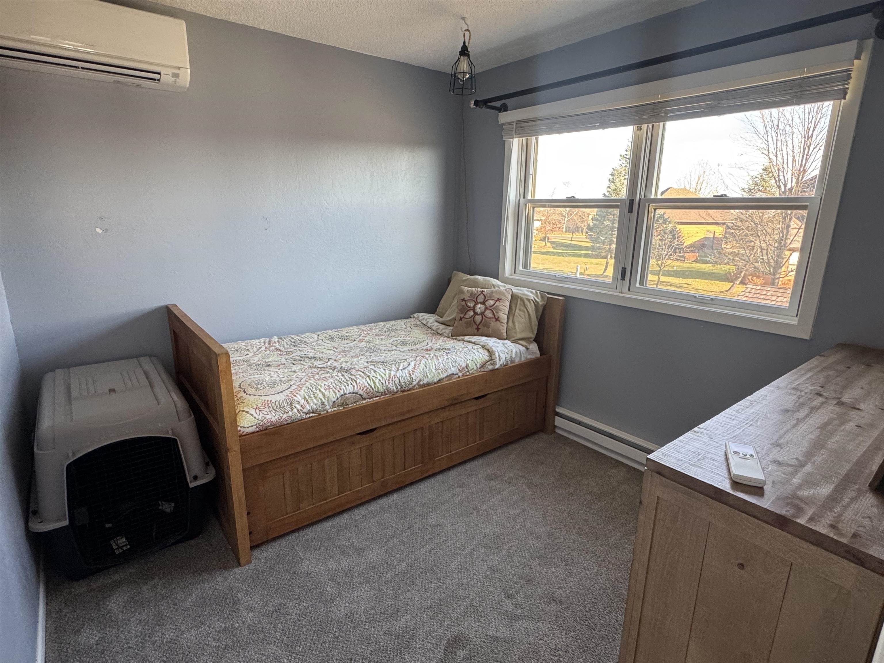 1217 North 33rd Street Superior, WI 54880 - Photo 14 of 21 Bedroom with a wall mounted AC, dark carpet, a baseboard heating unit, and a textured ceiling