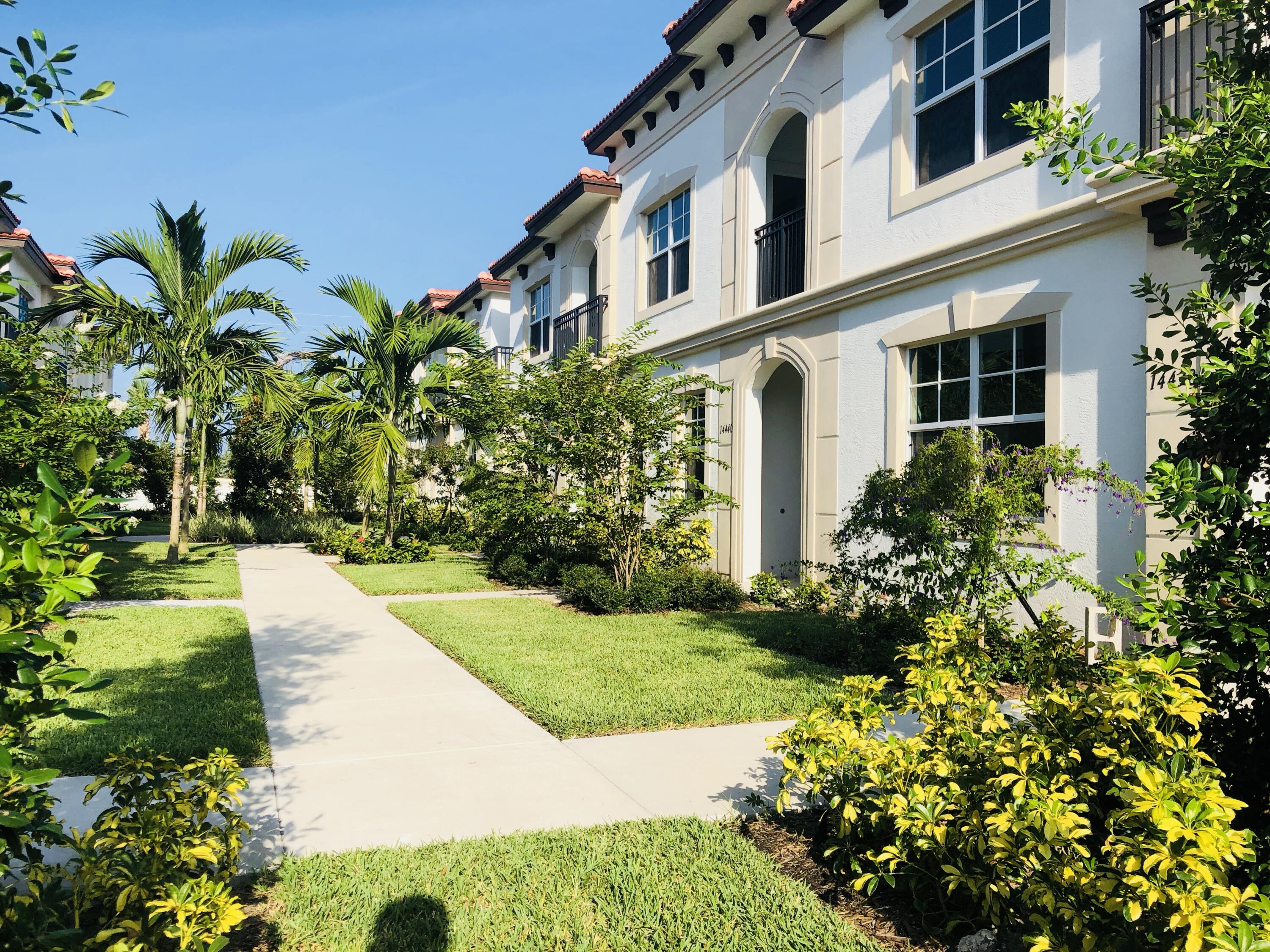 14426 Emerald Pl Way Delray Beach, FL 33484 - Photo 1 of 15 a view of a white house with a yard and flower plants