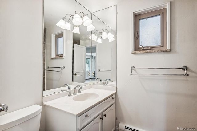 a bathroom with a sink vanity granite and toilet