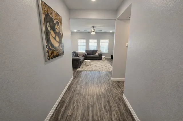 a view of a hallway with wooden floor and staircase