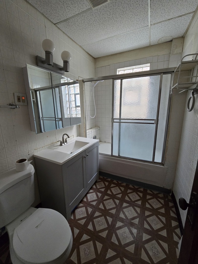 7517 South Green Street Chicago, IL 60620 - Photo 18 of 22 a bathroom with a sink toilet and mirror