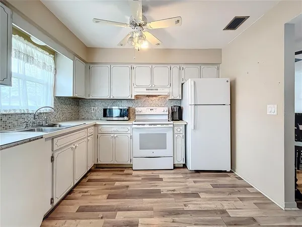 a kitchen with white cabinets and white appliances