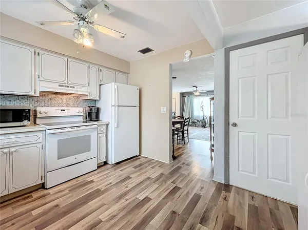 a kitchen with white cabinets and white appliances