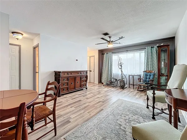 a living room with furniture a wooden floor and next to a window