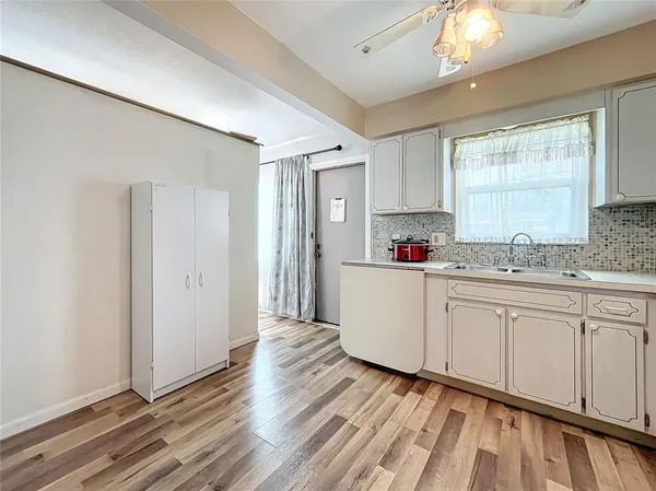 a kitchen with granite countertop a stove a sink and white cabinets