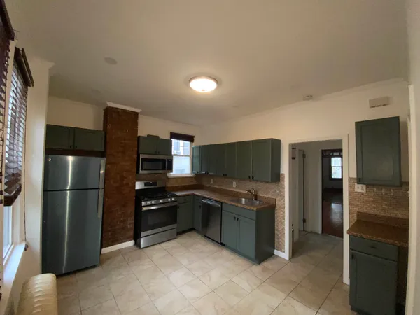 a kitchen with stainless steel appliances a refrigerator and a stove top oven