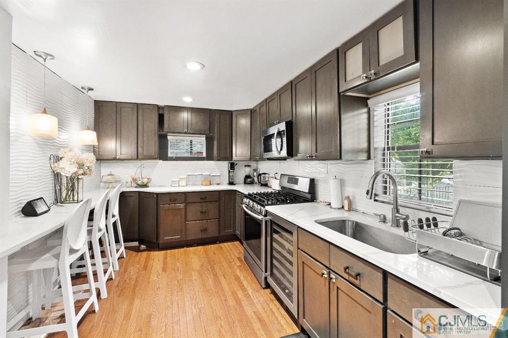 701 Spruce Street Roselle, NJ 07203 - Photo 11 of 28 a kitchen with stainless steel appliances granite countertop a sink stove and refrigerator