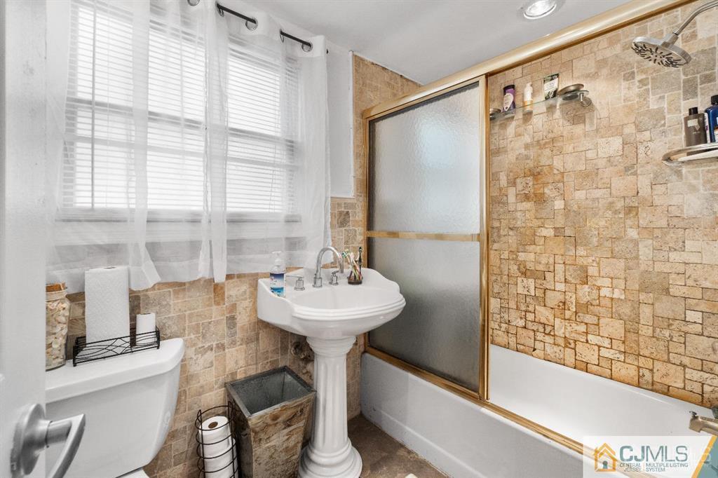 701 Spruce Street Roselle, NJ 07203 - Photo 18 of 28 a bathroom with a sink mirror and a bathtub