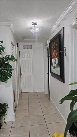 a view of a hallway with wooden floor and paintings on the wall