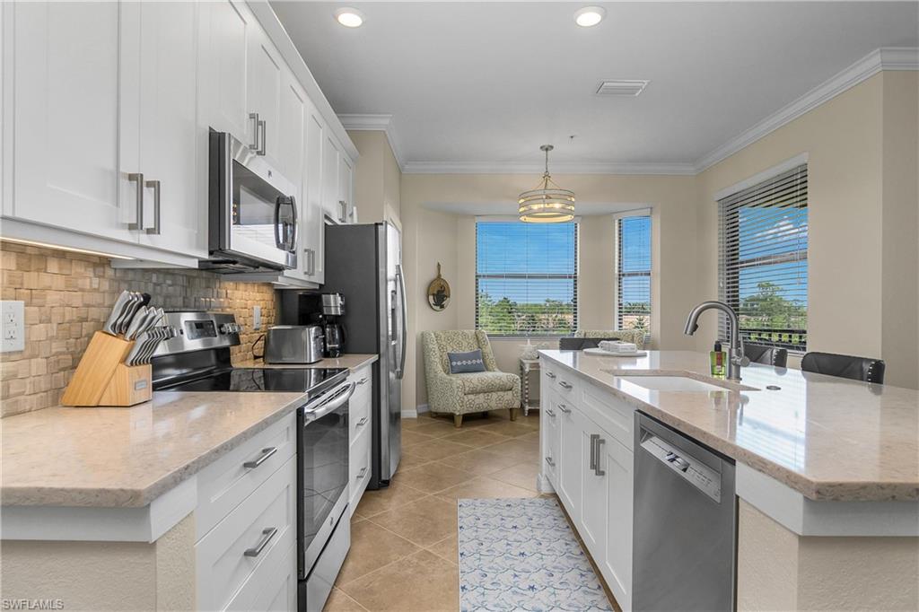 9834 Giaveno Circle, Unit 1746 Naples, FL 34113 - Photo 11 of 41 a kitchen with a sink stove and refrigerator