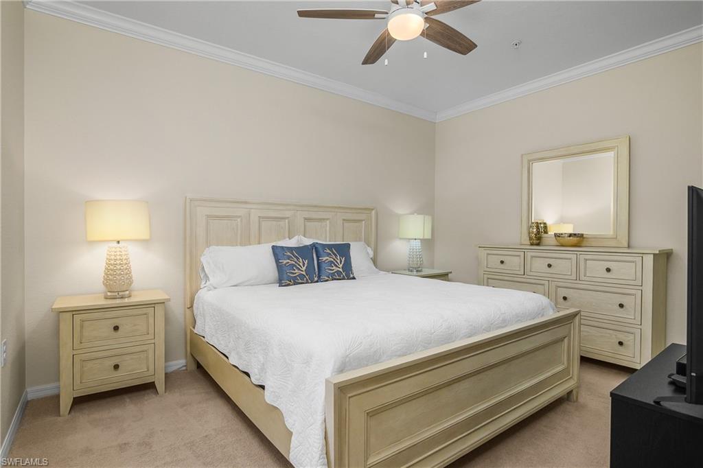 9834 Giaveno Circle, Unit 1746 Naples, FL 34113 - Photo 16 of 41 a bedroom with a bed and a chandelier